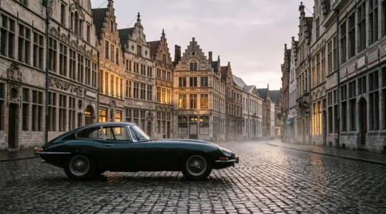 Silhouette d'une voiture de sport classique devant une architecture urbaine belge au lever du jour, symbole de l'histoire automobile